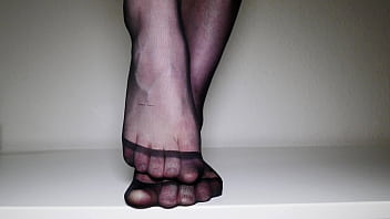 Feet in black pantyhose tights